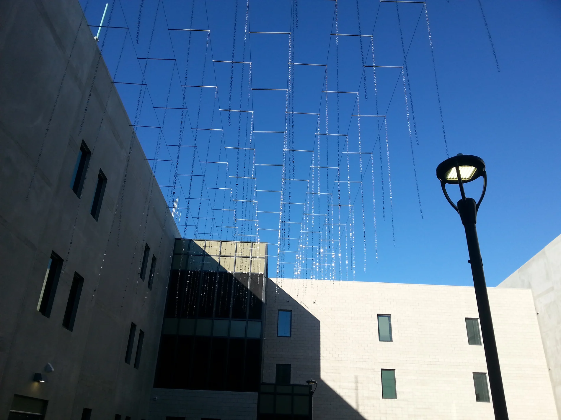 Suspended rain elements being installed in the courtyard